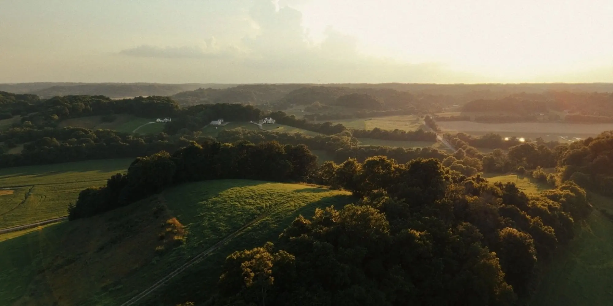 Drone view over rolling farmland and treeline in Williamson County, Tennessee at golden hour